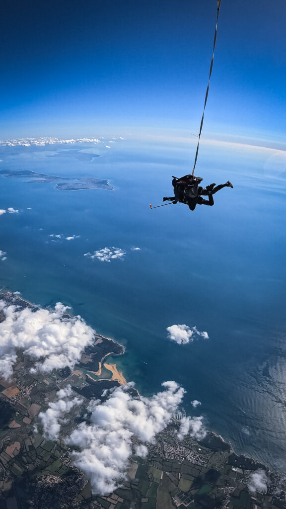 Un parachutiste de Vendée Evasion Parachutisme en chute libre surplombant les plages du Veillon, l'île de Ré et l'île d'Oléron depuis les Sables d'Olonne