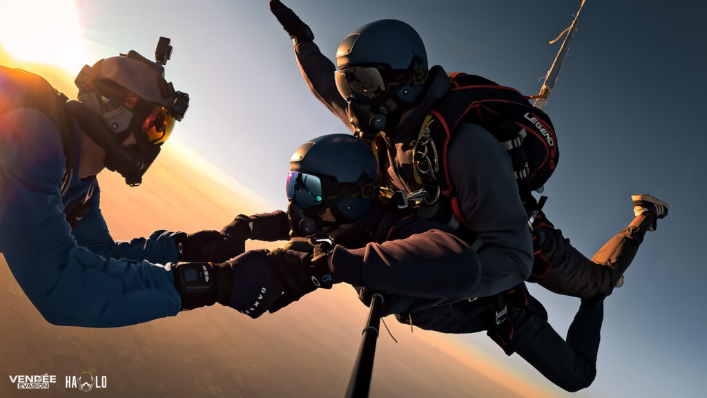 Deux parachutistes tandem en pleine action, profitant de la vue panoramique époustouflante sur les paysages vendéens.