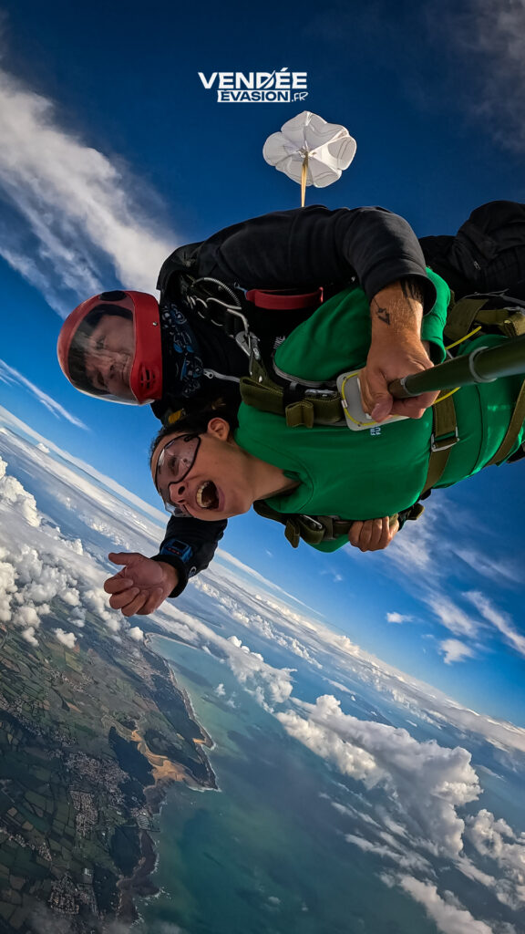 Une passionnée de sensations fortes en pleine descente en tandem avec un moniteur expérimenté de Vendée Evasion Parachutisme.